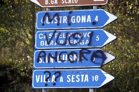 Giovane imbratta cartello stradale spruzzando vernice. La Cas...
